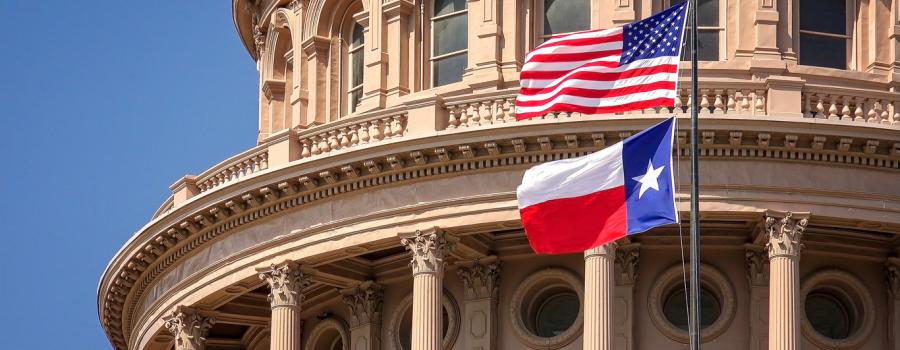 American and Texas state flags flying on the dome of the Texas State Capitol 